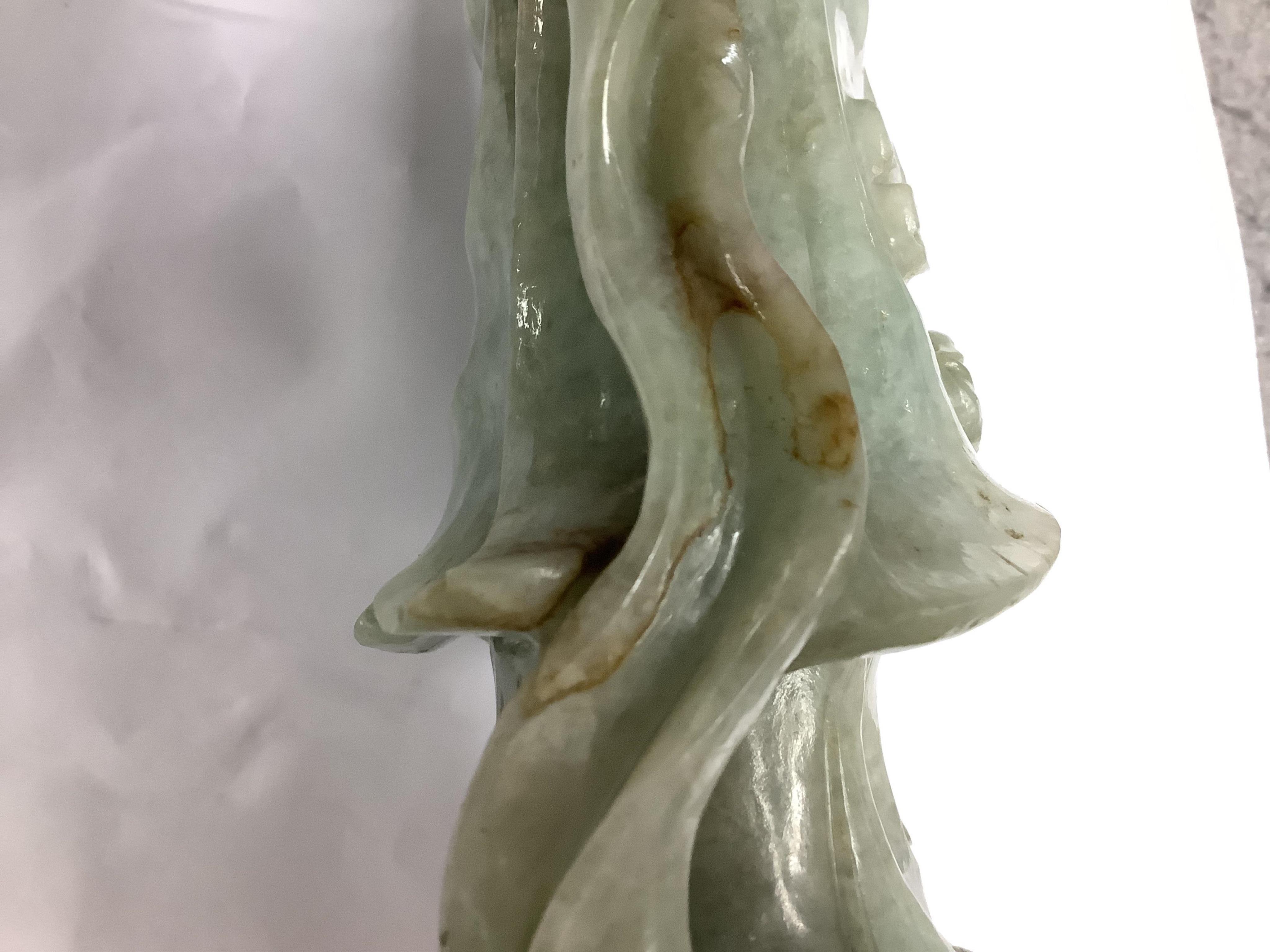 A Chinese jadeite carving of Guanyin, on associated hardwood stand, 38cm high. Condition - fair